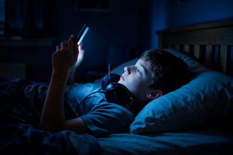 Gece yatağında telefon kullanan ergen, ekran bağımlılığı